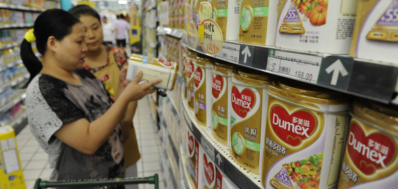 Una trabajadora de un supermercado ayuda a una clienta a comprar leche en polvo Dumex, filial de Danone, en Hefei, en la provincia china de Anhui (Reuters).